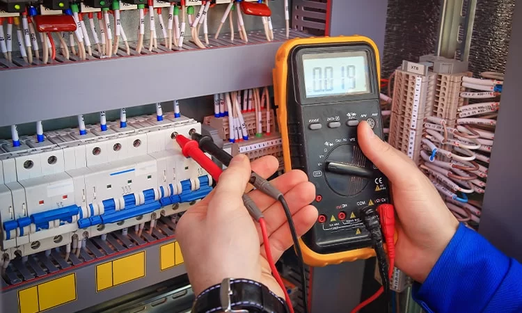 Electrician using a voltmeter to ensure safety and accuracy in Electrical Services Dubai for homes and businesses.