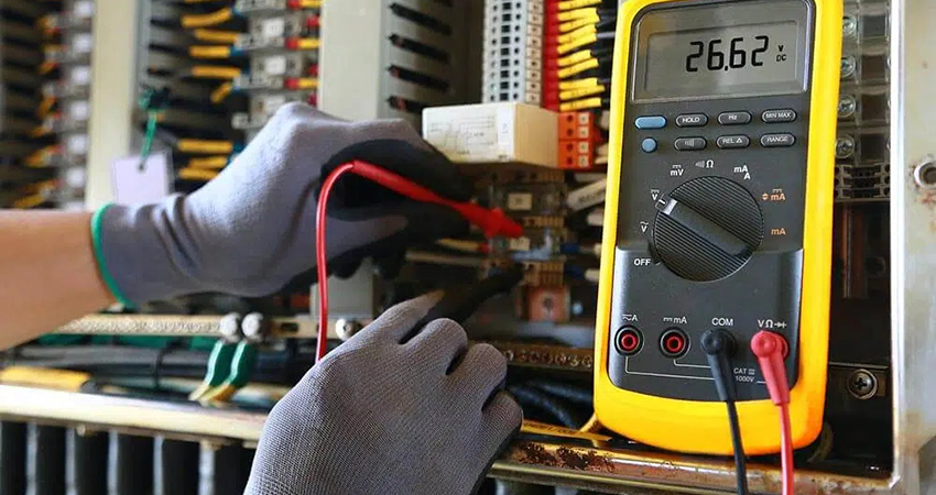 Electrician using a volt meter to ensure safety and precision, highlighting expert Electrical Services Dubai for homes and businesses.