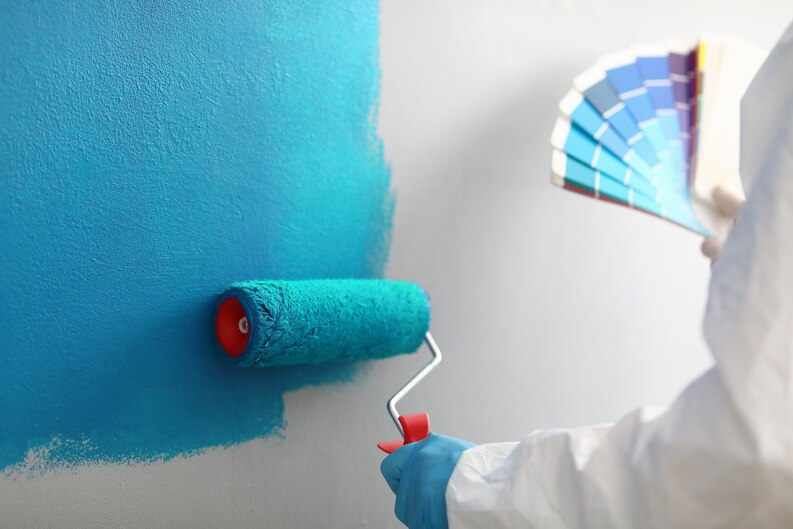 An expert painter applying a smooth coat of paint to a wall in a modern interior, showcasing professional Painting Services in Dubai for homes and offices.