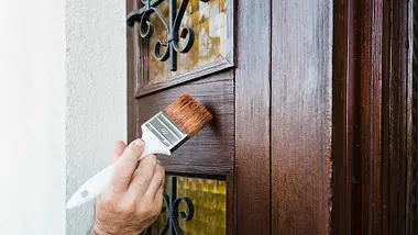 Hand painting a door with precision, showcasing Professional Door Painting Services Dubai for a flawless finish.