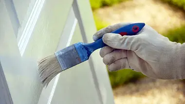 A hand carefully painting a door, showcasing Professional Door Painting Services Dubai with precision and attention to detail.